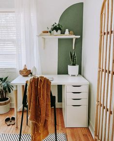 a room with a white desk and some plants