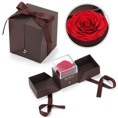 a red rose in a gift box with ribbon around it and other items for the package