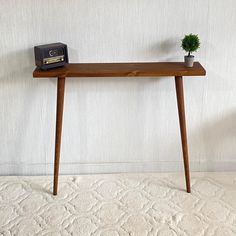 a wooden table with a radio on it and a potted plant next to it