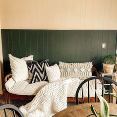 a living room filled with furniture and pillows on top of a wooden table next to a couch