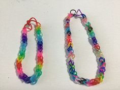 two colorful bracelets sitting next to each other on a white surface with one being made out of plastic beads