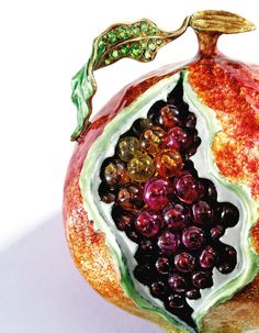 a close up of a pomegranate with grapes on it