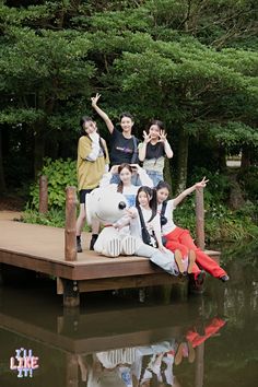 a group of people standing on top of a wooden dock