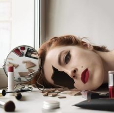 a woman laying on top of a table with makeup