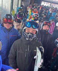 a group of people standing next to each other with skis on their heads and goggles on