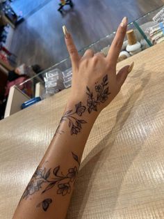 a woman's arm with flowers on it and a peace sign in the middle