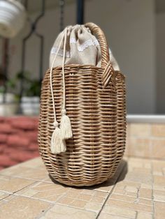 a wicker bag sitting on top of a tiled floor