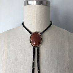 A lovely vintage bolo in perfect condition! Great gift for someone this holiday season! Introduction to Goldstone: Here's some good advice 🪶 Keep calm and carry the Goldstone crystal to ensure a golden future. Because let's be realistic--the mysterious abyss of the unknown--also known as the future--can be a daunting aspect. Known as the 'ambition' stone, the Goldstone crystal meaning is linked with boosting your drive and confidence, the essential mindset for paving the way for all your dreams 70s Jewelry Necklaces, Vintage Adjustable Jewelry For Western-themed Events, Vintage Necklaces With Adjustable Length For Festivals, Southwestern Jewelry With Adjustable Chain, Southwestern Style Jewelry With Adjustable Chain, Vintage Brown Jewelry With Adjustable Cord, Western Style Necklace With Adjustable Cord, Adjustable Cord Jewelry For Western-themed Events, Vintage Necklace With Adjustable Cord For Festivals