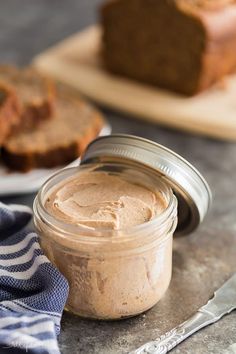 a jar filled with peanut butter next to slices of bread