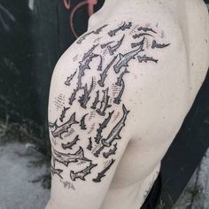 the back of a man's shoulder with many small sharks on it