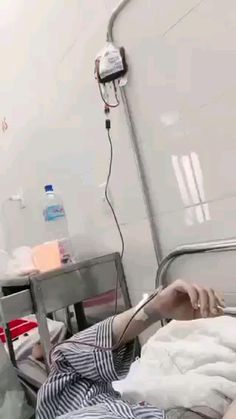 a person laying in a hospital bed with an iv hooked up to the head and arm