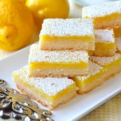 several pieces of cake sitting on top of a white plate next to an orange and some lemons