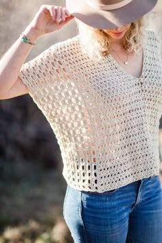 a woman in jeans and a hat poses for the camera with her hand on her hip