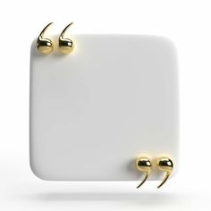 two gold ear studs sitting on top of a white board