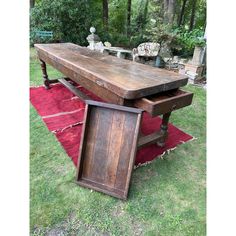 an old wooden table sitting on top of a red rug