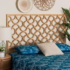 a bed with blue bedspread and pillows in front of two wall hangings