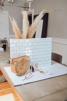 a table topped with a basket filled with lots of stuff next to a mirror on top of a wall