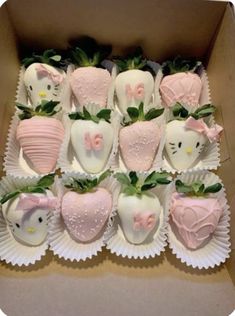 hello kitty chocolate covered strawberries are arranged in a box with green leaves and pink bows