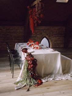 the table is set up with flowers and greenery for an elegant wedding reception or special event