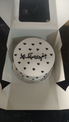 a white cake with black hearts in a box