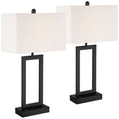 two black lamps with white shades on them