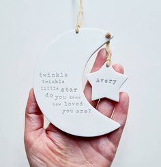 a hand holding a white ceramic ornament with a poem on it that says twinkle, twinkle, little star do you need how loved you are?