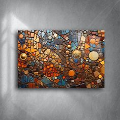 a mosaic tile wall hanging on the side of a gray wall with an orange and blue design