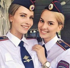 two women in uniform posing for the camera