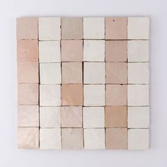 a white and pink tile wall hanging on a wall