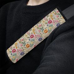 a close up of a person wearing a black shirt and holding a flowered wristband