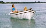 a woman sitting on top of a white boat in the water