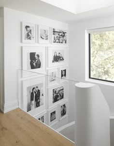 a white staircase with pictures on the wall