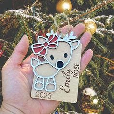 a hand holding a christmas ornament with a koala on it's head