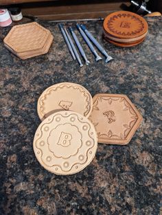 three wooden coasters sitting on top of a counter next to some paintbrushes