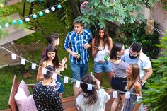 a group of people standing on top of a wooden deck next to a lush green forest