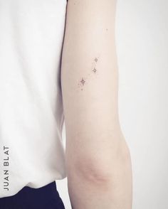 a person with a small star tattoo on their left arm and the other arm behind her