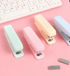 four different types of usb devices sitting next to a keyboard on a pink surface with one plugged in