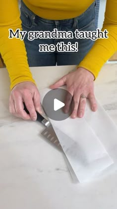 a woman cutting paper with a knife on top of it