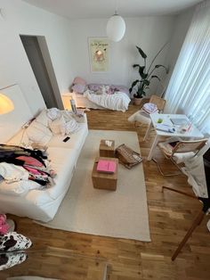 a living room filled with furniture and lots of clutter on top of the floor