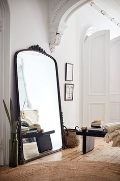 a large mirror sitting on top of a wooden floor