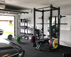 a man is working out in the garage with his car parked next to him,