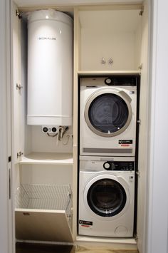 a washer and dryer in a small room next to a cabinet with an open door