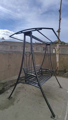 a metal swing set sitting on top of a cement ground