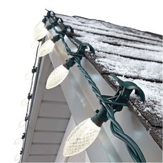 christmas lights are hanging on the roof of a house in the snow, with icing around them