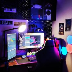 a man sitting at a desk in front of a computer monitor and keyboard with lights on