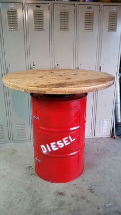 a red barrel with a wooden table top in front of some lockers on the floor