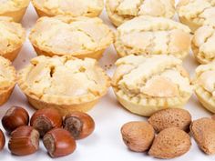 several different types of pies and nuts on a white surface