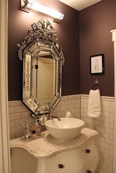 a white sink sitting under a mirror in a bathroom