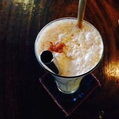 a drink in a glass with a straw sticking out of it on top of a wooden table