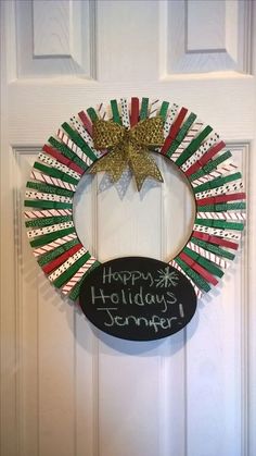 a holiday wreath is hung on the front door with a chalkboard saying happy holidays jenny